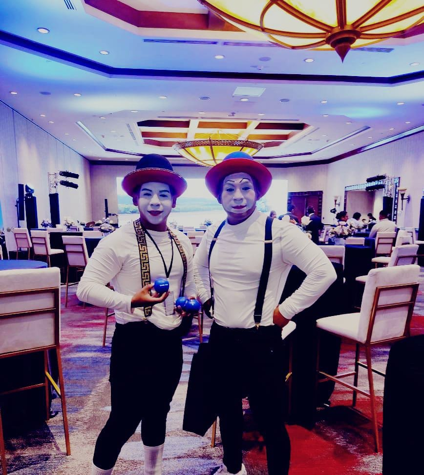 Dos mimos con pelotas de malabares en un salón de eventos